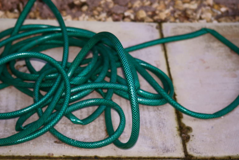 This photo of a garden hose with kinks illustrates the bottlenecks that impede workflow in the business office.